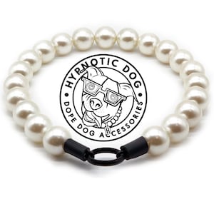 May include: A circular pet collar made of white spherical beads with a black metal ring clasp. In the center is a circular logo featuring a dog wearing spiral-patterned glasses with the text HYPNOTIC DOG DOPE DOG ACCESSORIES.