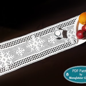 May include: White crocheted table runner with a delicate pattern. The runner is laid on a dark wood table with a white plate holding fruit and a candle.