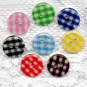May include: Assortment of eight plastic buttons with a gingham pattern. The buttons are in various colors, including pink, green, blue, yellow, red, and black.