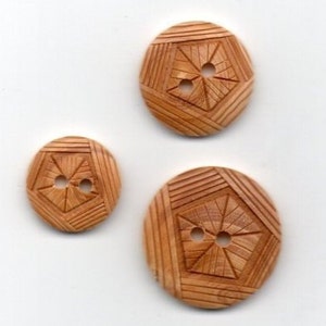 May include: Three wooden buttons with a geometric design. The buttons are brown and have two holes each.