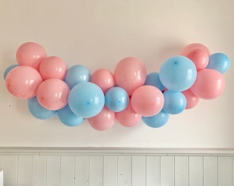 DIY gender reveal balloon garland made from blue and pink balloons, balloon arch for baby shower, shower surprise decoration