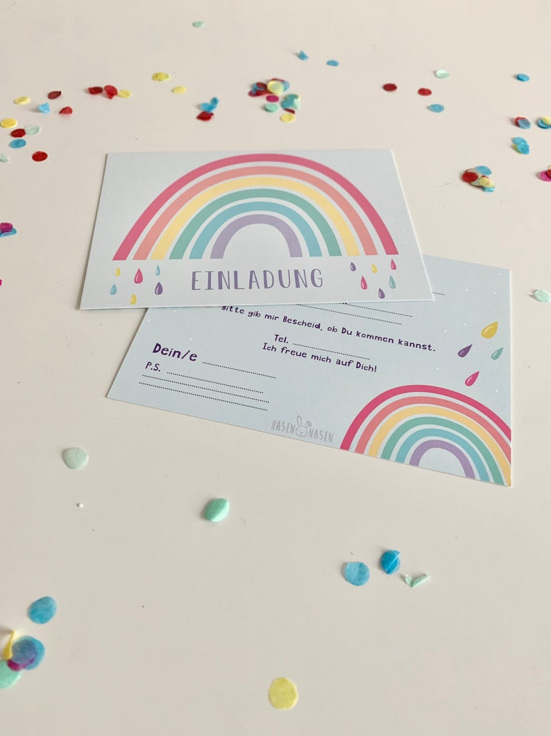 May include: A light blue invitation card with a rainbow design and the text "EINLADUNG" in black. The text "Bitte gib mir Bescheid, ob Du kommen kannst." is also included.