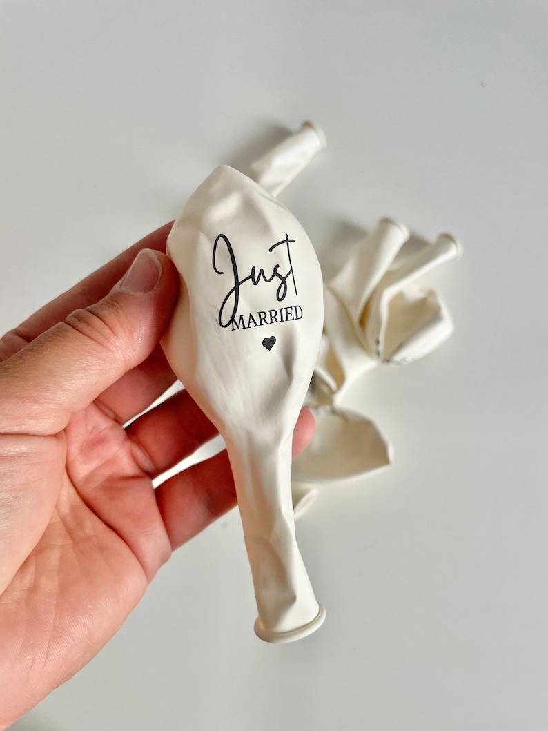 Peut inclure: Ballons en latex blancs avec le texte "Just Married" imprim&eacute; en &eacute;criture noire avec un petit c&oelig;ur.