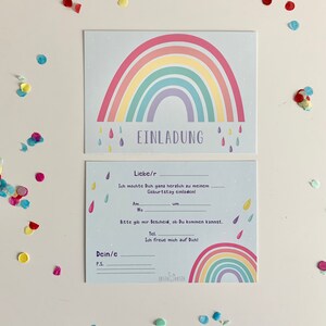 May include: A blue and white invitation card with a rainbow design and the text "EINLADUNG". The card has space for the recipient's name, date, time, and location of the event. The card also has a space for a personal message.