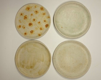 Set aus vier Porzellantellern mit unterschiedlichen Glasuren, handgebaute Brot- und Kuchenteller