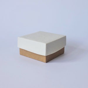 Caja fabricada con tapa de porcelana y fondo de cartón.