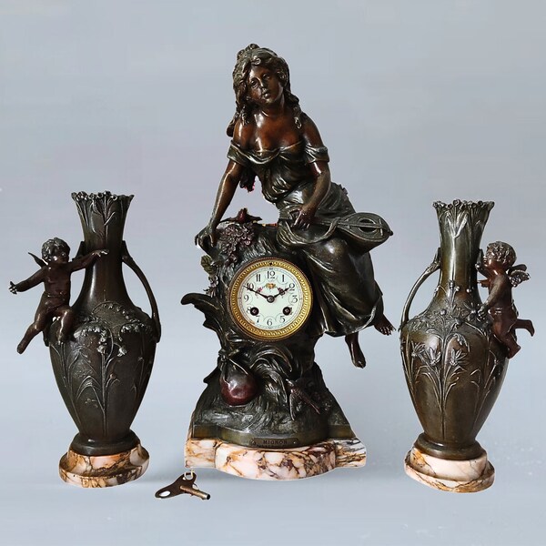L & F Moreau Bronze Samac three-piece clock set made of artificial bronze, consisting of a mantel clock and two decorative vases