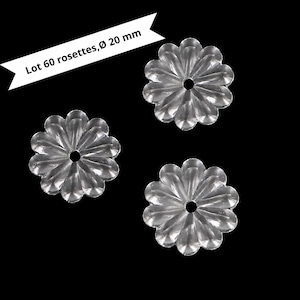 May include: Clear, flower-shaped embellishments with a 20 mm diameter. The image shows three of these decorative rosettes against a black background. The text in the image reads "Lot 60 rosettes, Ø 20 mm".