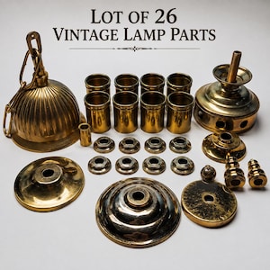 Op de afbeelding: Een set van 26 messingkleurige vintage lamponderdelen, inclusief een grote geribbelde plafondkap met ketting, acht cilindrische hulzen, diverse ronde voetstukken en kleine eindstukken. De tekst "LOT OF 26 VINTAGE LAMP PARTS" staat bovenaan.
