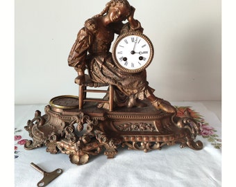 Un reloj de sobremesa antiguo con una llamativa escultura de una niña sentada en un banco: una escena muy realista.