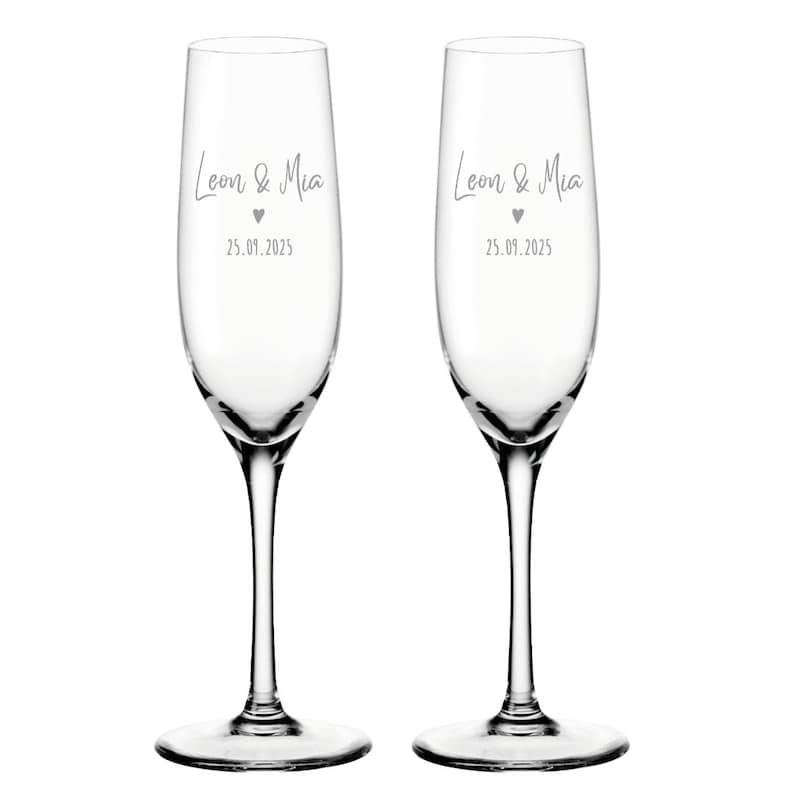 K&ouml;nnte beinhalten: Zwei klare Champagnerfl&ouml;ten aus Glas mit dem Text "Leon & Mia" und dem Datum "25.09.2025" auf jeder.