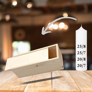 May include: A wooden box with a sliding lid, perfect for storing candles. The box is made of natural wood and has a rustic look. The box is shown next to a white candle with the numbers 25/8, 25/7, 20/8, and 20/7 printed on it.