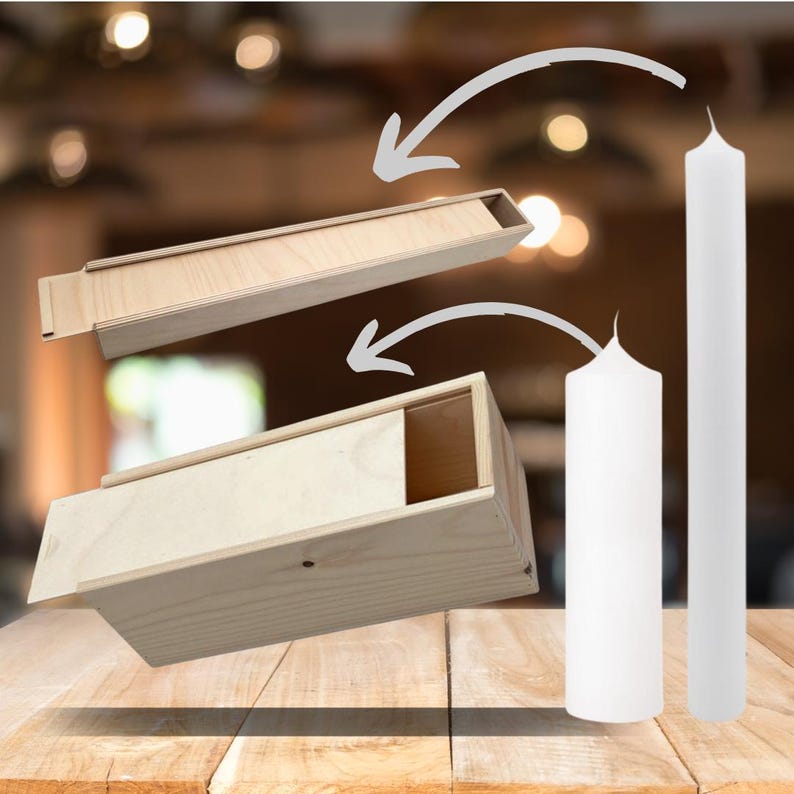 May include: Two white pillar candles in a wooden box with a sliding lid. The box is made of light wood and has a natural finish. The candles are tall and slender, and they are both standing upright.