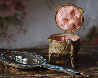 Joyero francés antiguo, estilo Regule, de Napoleón III, con borlas de seda y satén color melocotón.