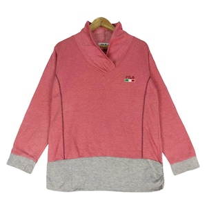 May include: A pink and grey long-sleeved sweatshirt with a mock neck and a contrasting grey band at the bottom. The sweatshirt has the word "FILA" embroidered on the front in white with the Italian flag.