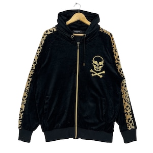 Puede incluir: Sudadera con capucha negra de terciopelo con un diseño de calavera y huesos cruzados dorados en la parte delantera. Las mangas tienen un estampado de leopardo.