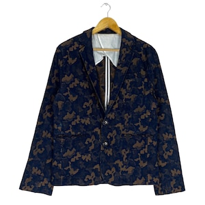 May include: A dark blue blazer with a brown camouflage pattern. The blazer has a single-breasted closure with two buttons and two flap pockets.
