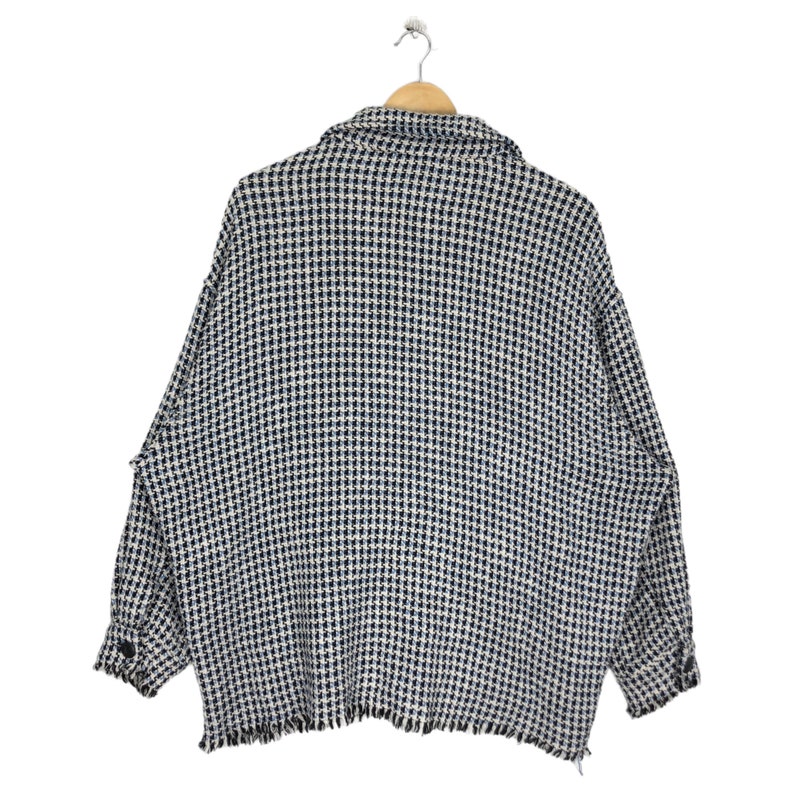 May include: A black and white checkered button-up shirt with a frayed hem.