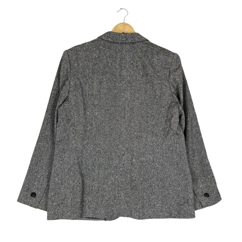 May include: A gray tweed blazer with a single button closure and long sleeves. The blazer has a classic fit and is made of a soft, comfortable fabric.