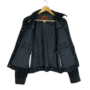 May include: A black denim jacket with a corduroy collar and a brown label that says "Gap" on the inside. The jacket has two pockets on the front and two pockets on the inside.
