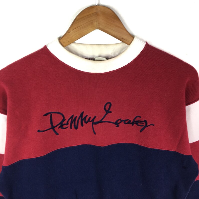 May include: Red, white, and blue striped sweatshirt with a navy blue embroidered logo that says "Penny Loafers".