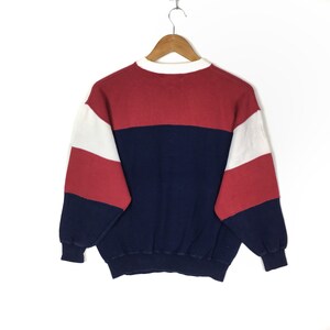 May include: A red, white, and blue striped sweatshirt with a crew neck.