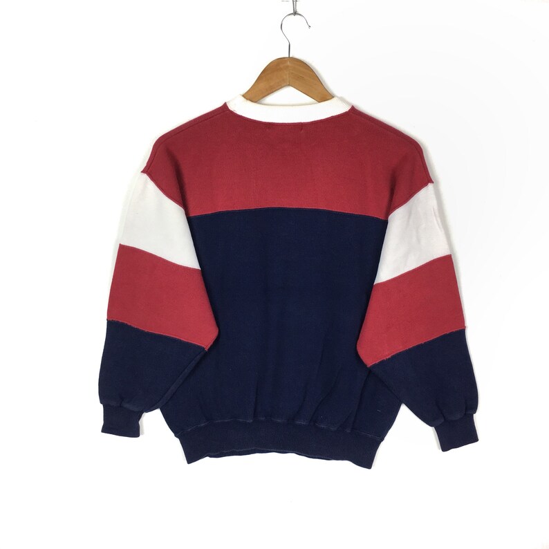 May include: A red, white, and blue striped sweatshirt with a crew neck.