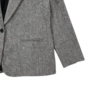 May include: A gray blazer with a speckled pattern. The blazer has a single button closure and a pocket on the left side.