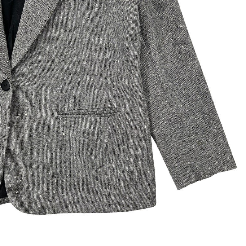 May include: A gray blazer with a speckled pattern. The blazer has a single button closure and a pocket on the left side.