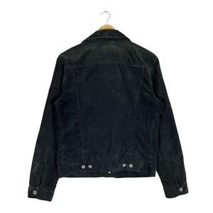 May include: A black corduroy jacket with a button-up front and long sleeves. The jacket has a classic denim jacket style.