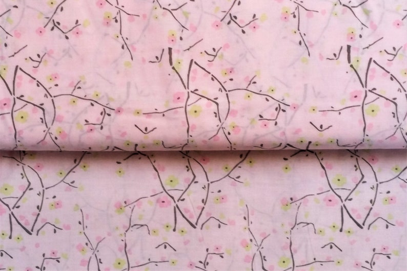 May include: Pink fabric with a repeating pattern of black branches and small pink and yellow flowers.