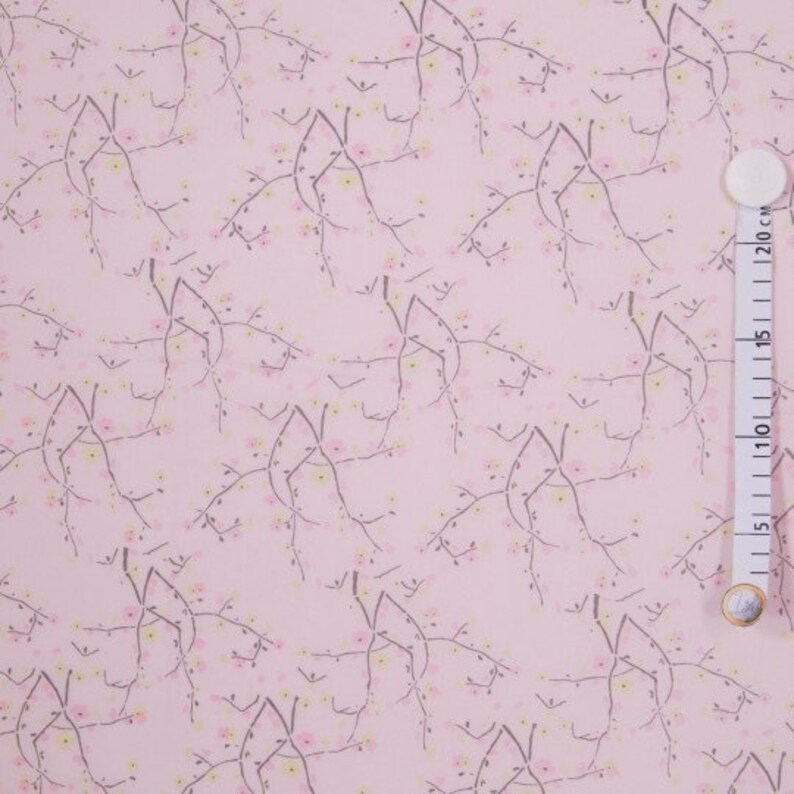 May include: Pink fabric with a repeating pattern of delicate grey branches with small pink and yellow flowers.