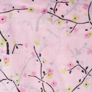 May include: A pink fabric with a delicate floral pattern. The pattern features black branches with small pink and green flowers.