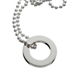 Könnte beinhalten: Eine silberne Halskette mit einem runden Anhänger. Die Halskette besteht aus einer Kette aus kleinen silbernen Perlen.
