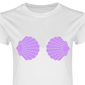 Könnte beinhalten: Ein weißes T-Shirt mit einem lila Muschel-Design auf der Vorderseite. Die Muscheln sind so positioniert, dass sie wie ein Paar Brüste aussehen.