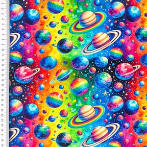 Könnte beinhalten: Ein farbenfroher Stoff mit einem sich wiederholenden Muster aus Planeten und Sternen. Die Planeten sind blau, grün und orange mit Regenbogenringen. Der Hintergrund ist ein Regenbogenverlauf.