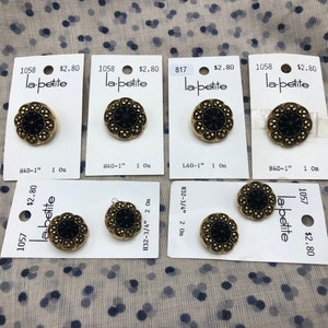 May include: Several vintage black and gold buttons with the text "la-petite" on the tags. The buttons have a floral design and are approximately 1 inch in diameter. The tags also include the numbers 1058, 817, and 1057.