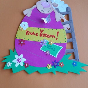 Janela com imagem de ovelha de papelão de argila e ovo grande de Páscoa