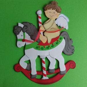 Raamfoto van karton Kerstengel op hobbelpaard