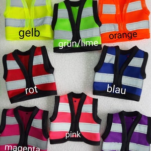 Puede incluir: Siete chalecos de seguridad en diferentes colores: amarillo, verde, naranja, rojo, azul, rosa y morado. Cada chaleco tiene tiras reflectantes y un ribete negro. Los chalecos est&aacute;n etiquetados con las palabras alemanas para cada color.