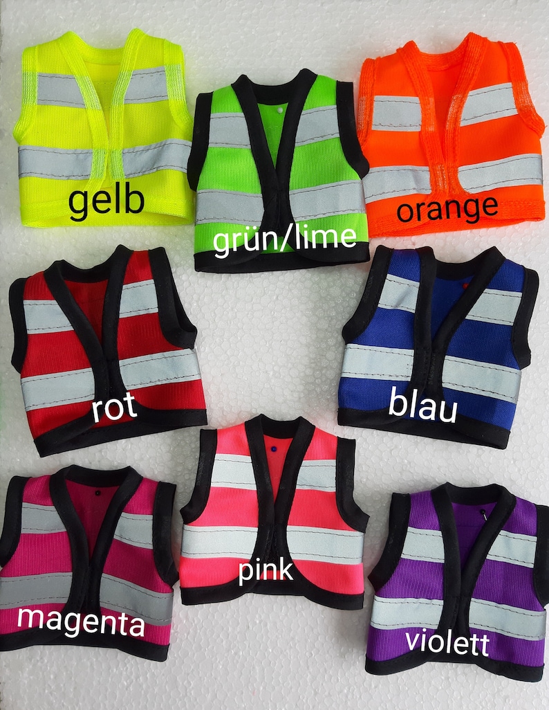 Puede incluir: Siete chalecos de seguridad en diferentes colores: amarillo, verde, naranja, rojo, azul, rosa y morado. Cada chaleco tiene tiras reflectantes y un ribete negro. Los chalecos est&aacute;n etiquetados con las palabras alemanas para cada color.