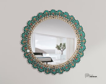 May include: A round mirror with a decorative frame featuring a teal blue background with floral designs in pink, white, and yellow. The frame has a scalloped edge.