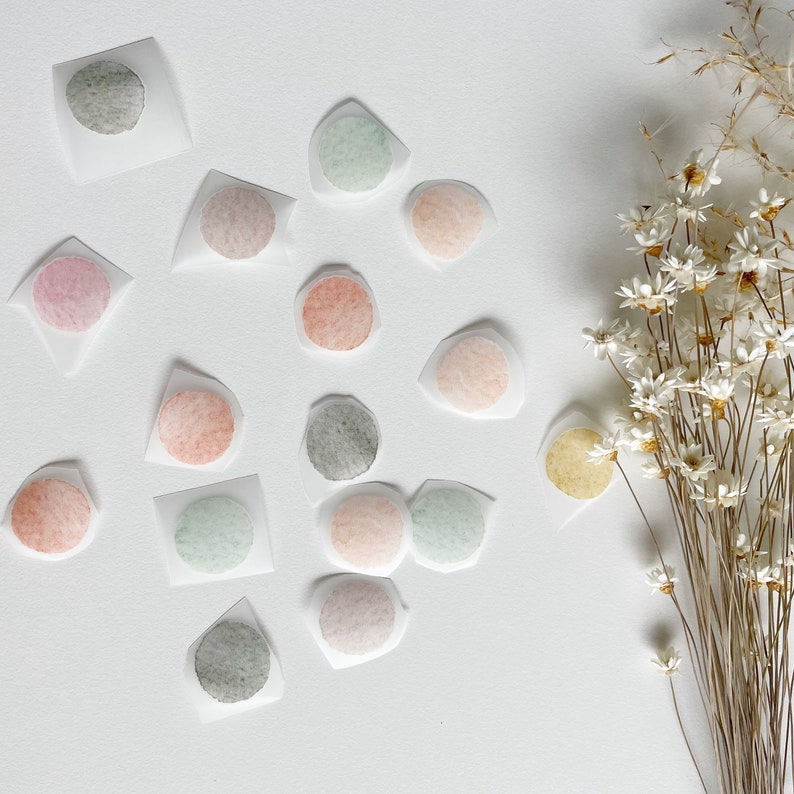 May include: Assortment of colorful watercolor circles on white paper. The circles are in various shades of pink, green, brown, and gray. The circles are arranged in a random pattern on the paper.