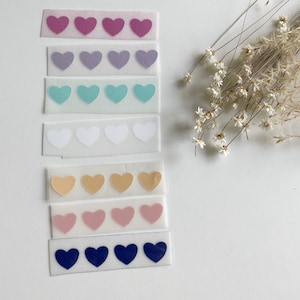 May include: Eight strips of clear adhesive tape with rows of heart-shaped stickers in various colors, including pink, purple, blue, white, beige, light pink, and navy blue.