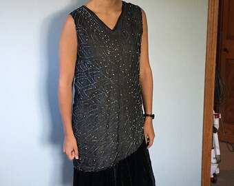 May include: A sleeveless black dress with a beaded bodice and a black velvet skirt.