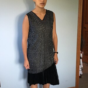 May include: A sleeveless black dress with a beaded bodice and a black velvet skirt.