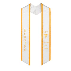 May include: White graduation sash with gold trim and text. The left side reads "NURSING" vertically in gold. The right side features "LPN", a medical symbol, and "CLASS OF 2026" in gold.