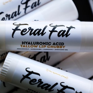May include: White lip balm tubes with the words "Feral Fat" in a black script font. The label also includes "Hyaluronic Acid Tallow Lip Chubby" and the ingredients: chamomile, huruhuru, capuacu, and avocado oil.