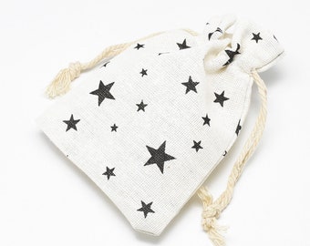 Pode incluir: Uma bolsa branca de cordão com estampa de estrelas pretas. A bolsa é feita de um tecido natural e tem um design simples.