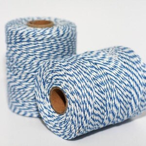 May include: Two spools of blue and white baker's twine. The twine is wound around cardboard spools.